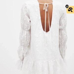 Vit kort klänning med broderade blommor - Superfin vit kortklänning med broderade blommor, volang nertill och långa puffärmar. Klänningen har öppen rygg med knytband💕Helt ny med prislappen kvar! Nypris 699kr, jag säljer för 599kr + frakt🌟