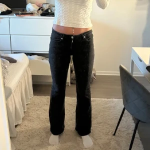 Svarta bootcut jeans med låg midja - Säljer ett par svarta jeans ifrån mango. Innerbenslängd: 82, midjemått: 37