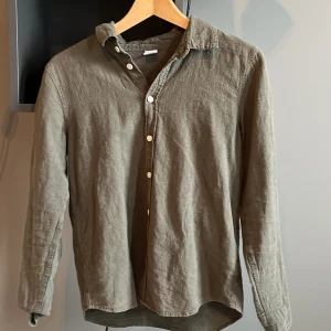 Olivgrön långärmad skjorta - Säljer en olivgrön linneskjorta i storlek 160