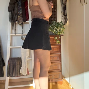 Svart kortkjol - Köpt secondhand men aldrig använt. Snygg svart kortkjol med dragkedja och fickor. Perfekt för en stilren look. Kjolen har en klassisk design som passar till många olika toppar och stilar.