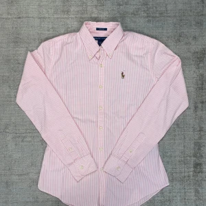 Randig skjorta från Ralph Lauren - Klassisk randig skjorta från Ralph Lauren med broderad logotyp på bröstet. 