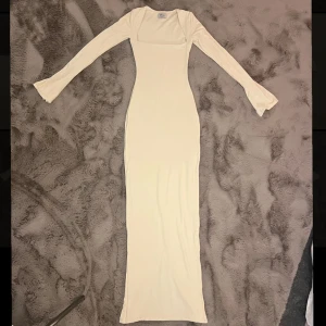 Klänning - Benvit, figurnära klänning med slits på baksidan. Storlek UK 4 som motsvarar xxs. Använd 1 gång, har inga fel förutom en fläck på baksida axel (bild 3). Köpt för 830 kr.