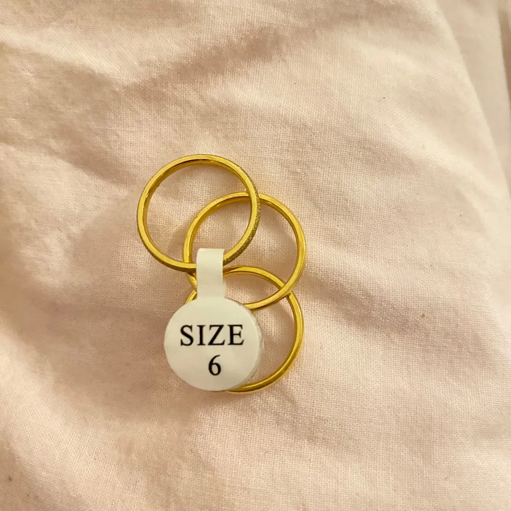 Snygga guldfärgade ringar i set om tre. Perfekt för att mixa och matcha med andra smycken. Storlek 6 enligt märkning. Enkla och stilrena för en elegant touch till din outfit.. Asusteet.