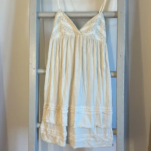 Vit klänning från Ralph Lauren - Säljer en söt vit klänning från Ralph Lauren med spetsdetaljer och smala axelband. Klänningen ärv-ringad och har volanger längst ner. Perfekt för varma sommardagar!☀️💕