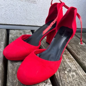 Röda högklackade sandaler! - Jättesnygga röda sandaler med klack och justerbar vristrem i storlek 41 från Attitude. Klackhöjd 8 cm. Endast använda ett fåtal gånger. Små spår av användning finns. Mycket fint skick!