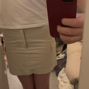 Beige kortkjol med fickor - Säljer en stilren beige kortkjol med fickor på sidorna. 