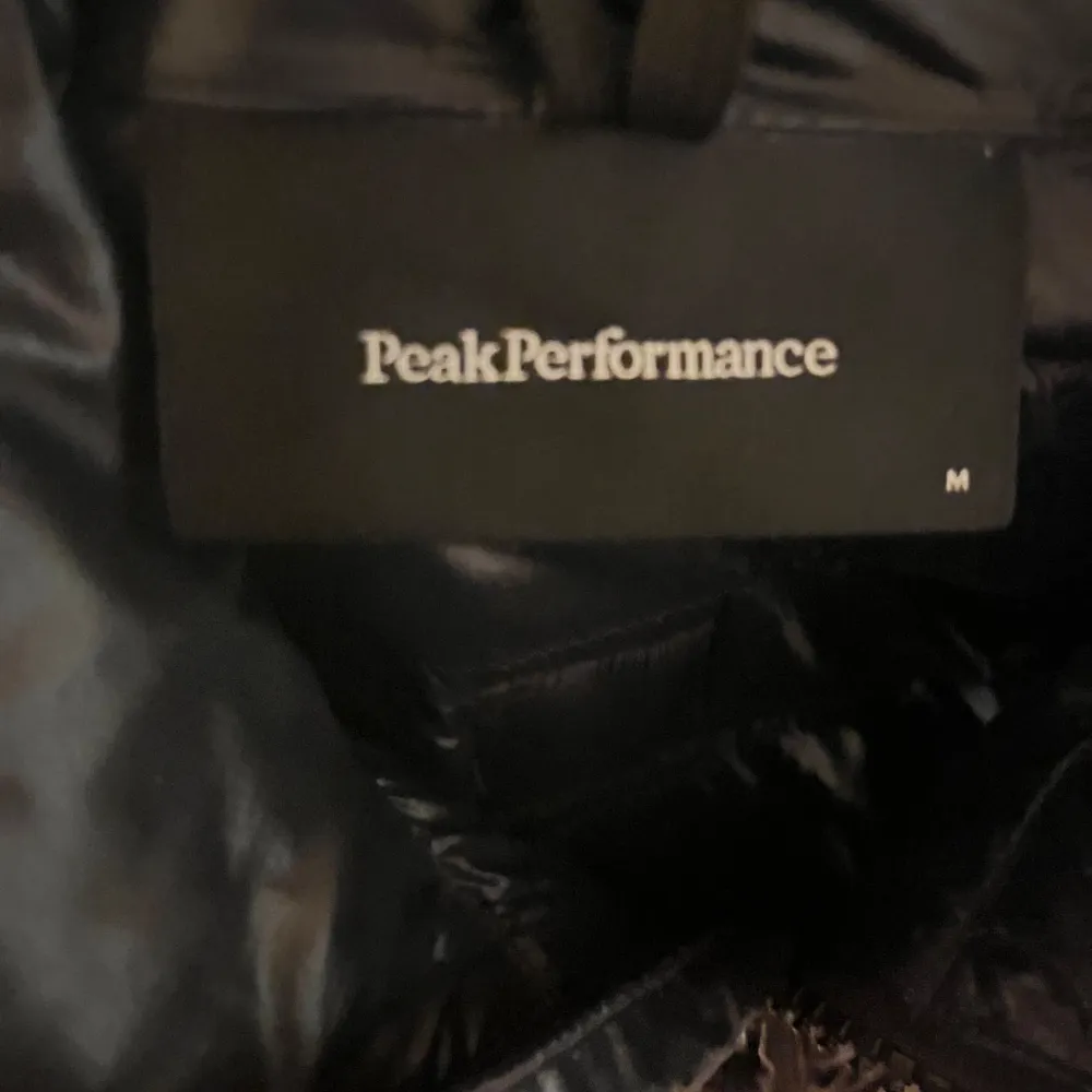 Snygg mörkblå dunväst från Peak Performance med dragkedja framtill. Perfekt för lager-på-lager under kyliga dagar. Västen har en stilren design med diskret logga vid nacken. Köparen står för frakt.. Takit.
