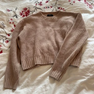 Beige stickad tröja från bershka - Säljer en mysig beige stickad tröja från Bershka. Tröjan har en rund halsringning och långa ärmar med ribbade muddar. Perfekt för kyliga dagar. Hör av dig vid intresse!