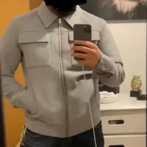 Grå kappa  - Säljer en stilren grå kappa med dragkedja och klassisk krage. Aldrig använt då den inte riktigt föll i smaken. Nyskick. Köpt från Jack&Jones.