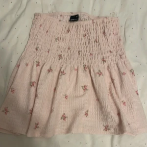 topp från gina! - Söt rosa tröja från Gina Tricot med blommigt mönster. den sitter jättefint, kan användas som både kjol och tröja! 