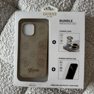 Beige mobilskal från Guess - Snyggt beige mobilskal från Guess. Köpt i London men missade tyvärr att det endast var för IPhone 15 så det passar ej min mobil! Skalet är en del av ett 3-i-1 skyddspaket som inkluderar ett skal, kameraskydd och skärmskydd. Förpackningen är öppnad men aldrig använd, därför är förpackningen lite bruten inuti! Skriv vid frågor eller bud ☺️