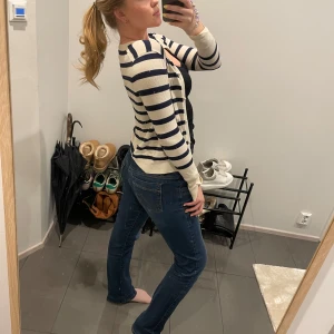 Randig kofta från Zara - Säljer en snygg randig kofta från Zara i beige och blått. Koftan har långa ärmar och en klassisk design som passar perfekt till jeans. Perfekt för en stilren look!