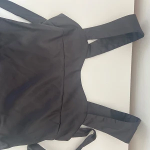 Svart satin topp med knytning i bak  - Aldrig använd! Supersöt. Pris kan diskuteras vid snabbt köp 