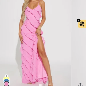 Rosa Felicia Ruffle Maxi Dress - Snygg rosa maxiklänning med volanger och en djärv slits. Köpte specifikt till balen men var lite för stor på mig för att jag är byggd som en pinne, jätte fin kvalité inte genomskinlig och helt oanvänd