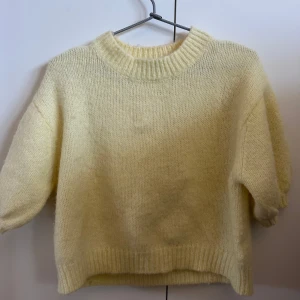 Gul stickad tröja från Zara - Säljer en mysig gul stickad tröja från Zara. Tröjan har en rund halsringning och puffiga ärmar. I storlek S.