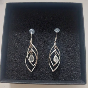 Eleganta silverörhängen med droppformad detalj - Snygga och eleganta örhängen i silver med en unik design. De har en droppformad detalj i mitten som ger en extra touch av stil. 💧