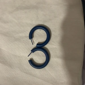 Blå örhängen i cirkelform - Snygga blå örhängen i cirkelform. Perfekta för att ge en färgklick till din outfit. De är enkla men stilrena och passar till många olika stilar.