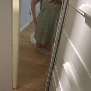 Grön klänning från petites  - Säljer en söt ljusgrön klänning från petites med volangdetaljer på axlarna och en v-ringad design. Perfekt för varma dagar och ger en härlig sommarkänsla. Klänningen har en luftig passform och är tillverkad i ett mjukt material.