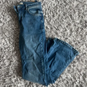 Blå bootcut jeans - Snygga blå bootcut jeans med klassisk femficksdesign. Perfekta för en avslappnad stil med en touch av retro. De har en bekväm passform och är tillverkade i ett slitstarkt denimtyg.