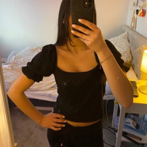 Svart kortärmad topp från NA-KD - Säljer denna super söta och stilrena svarta toppen med puffärmar från NA-KD. Perfekt till våren/sommaren!!☀️Jag säljer toppen på grund av att den inte används längre, men har lite tecken på användning (se sista bilden).❤️