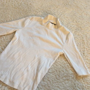 Polotröja - En stilren vit ribbad polotröja med trekvartsärmar💓