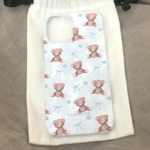 Mobilskal med nallemönster - Sött mobilskal med ett mönster av små nallar och blå rosetter. Perfekt för att ge din telefon en gullig och unik look. Skalet är lätt och smidigt att använda. Finns lite märken som kommit när jag tappat telefonen men dem syns knappt. nypris är 299kr