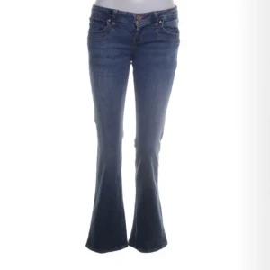 Ltb jeans  - Snygga blå bootcut jeans med klassisk femficksdesign och knappgylf. Perfekta för en avslappnad stil med en touch av retro. Passar bra till både sneakers och klackar.