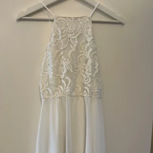 Vit spetsklänning från Ivyrevel - Säljer en vacker vit klänning från Ivyrevel med spetsdetaljer på överdelen och tunna axelband. Klänningen har en luftig kjol och är perfekt till studenten eller sommaren. Har tyvärr klippt bort lappen på den men är storlek S och kan skicka mått på den om man vill veta exakt. Använd 1 gång!