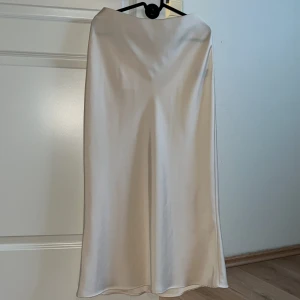 Krämvit långkjol från Zara - Krämvit långkjol från Zara i silke. Kjolen är helt ny och prislappen sitter kvar. 