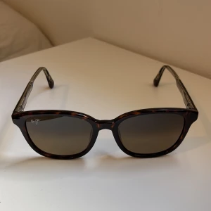 Bruna solglasögon Maui Jim - Snygga solglasögon från Maui Jim. Använda ett fåtal gånger. Original pris 2699kr mitt pris 499kr. Perfekt för dig som vill ha en stilren och trendig accessoar. Inga defekter.