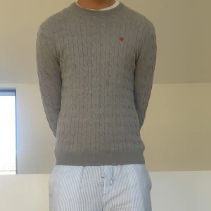 Grå Morris tröja - Säljer en sjukt fet Morris tröja som är ribbonstickad. Tröjan är grå och är gjord i 100% Merino ull. Nypris ligger på ca 1700 och tröjan sitter i ungefär strl S men är egentligen en L. Den är i mycket bra skick och har därav inga defekter och hör gärna av er vid frågor eller funderingar!!