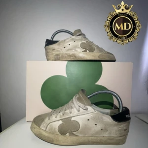 Beige sneakers från The Gallerist - Snygga beige sneakers från The Gallerist med svart häl och klöverdetalj på sidan. Skorna har snörning, rund tå och platt sula. Ovandelen är i mocka och skinn, vilket ger en schysst vintage vibe. Perfekta för dig som gillar stilrena men unika detaljer. Skorna ska se lite trasiga ut de är modellen! Skorna är storlek 38 men sitter som 38,5. Box ingår! Skirv vid frågor eller mer bilder⚜️