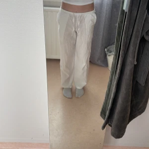 Vita linnebyxor från Gina Tricot - Säljer ett par vita linnebyxor från Gina Tricot med avslappnad passform och dragsko i midjan. Byxorna har raka, vida ben och är tillverkade i svalt linnematerial. Perfekta för varma dagar och chill vibes.