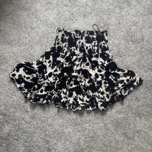 Blommig söt volangkjol - Supersöt volang kjol från Pernilla Wahlgren med svart blommigt mönster🥰🥰