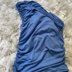 Blå one shoulder topp från NA-KD - Blå one shoulder topp från NAKD med rynkade detaljer längs sidan. I strlk S, (skriv för att se hur den ser ut på)💕