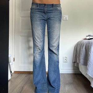 Blå bootcut jeans med utsvängda ben - Säljer ett par blå jeans med utsvängda ben. Midjemått:44cm innebenslängd: 84cm ytterbenslängd: 105cm