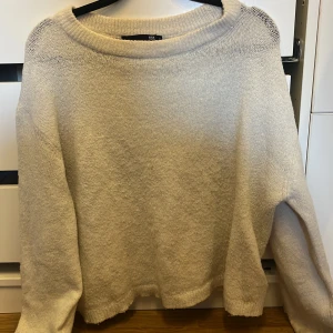 Vit stickad tröja från lager 157, M - Mysig vit  stickad tröja från 157 i storlek M. Tröjan har en rund halsringning, lång ärm och en relaxed passform. Perfekt för lager-på-lager och chill dagar. Enkel och stilren design som funkar till det mesta.Tröjan har fått en liten svag fläck på framsidan av tröjan men dom knappast syns!