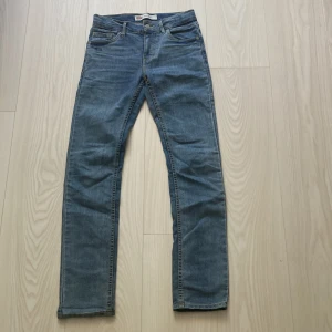 Levi's 510 Skinny jeans blå - Säljer ett par klassiska Levi's 510 Skinny jeans i blå denim. De har fem fickor, smal passform och snygga kontrastsömmar. Perfekta för dig som gillar en tajt look och vill ha ett par jeans som funkar till allt. Levi's-logga på bakfickan och etikett i midjan.