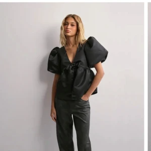 Svart satinblus med puffärmar - Super fin svart satin blus med en gullig rosett på framsidan. Aldrig andvänd nu med prislapp. Säljer pågrund av att jag väntade för länge med returnering 💓