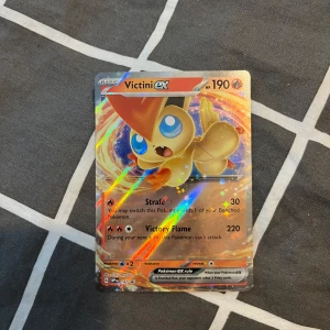 Victini EX 142 - Säljer ett Victini EX Pokémonkort med holografisk yta. Perfekt för samlare eller Pokémon-fans. HELT NYTT
