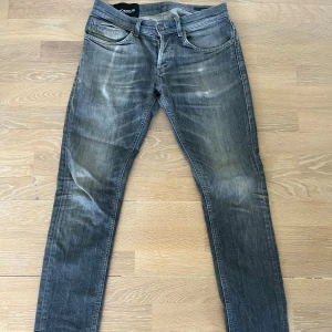 Ljusgrå Dondup jeans - Säljer ett par grå jeansbyxor från Dondup med raka ben. Jeansen har en lätt tvättad look och normal passform (George slim fit). Byxorna är i stort sätt fullt skick, däremot ljusare på vissa ställen som på bilderna efter tvätt och användning.