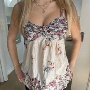 Blommig och fjärilsmönstrad topp🦋 - Världens sötaste topp som tyvärr blivit för liten för mig💔 Den är mönstrad med blommor och fjärilar i rosa, lila och beige. Den är helt perfekt för sommaren och är så flattering i passformen!