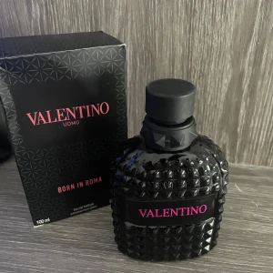 Valentino Uomo Born In Roma Eau de Toilette - En lyxig herrparfym från Valentino i en svart, mönstrad glasflaska med rosa text. Flaskan rymmer 100 ml och doften är modern och elegant. Endast använd 2-3 sprut 