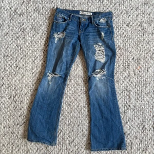 Blå lågmidjade bootcut jeans från Hollister - Midjemåttet är ca 38-39 cm. 