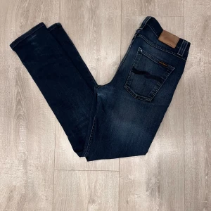 Nudie jeans grim trim - Säljer ett par nudie grim trim jeans som tyvärr har några slitningar. Sitter extremt bra, se bristningarna på sista bilden. Personen på bilden är 180 och väger 70kg. Skadorna är lagade så de inte ska sprida sig, finns även fler jeans på min profil😃