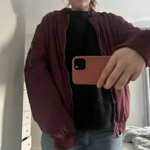 Vinröd bomberjacka från L.O.G.G. - Säljer en vinröd bomberjacka från L.O.G.G. På HM med silvrig dragkedja och fickor framtill. Jackan har lång ärm och ribbade muddar vid ärmslut och nederkant. Trendig och bra passform! Kan diskutera pris och svarar på frågor vid behov!💘