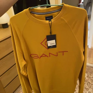 Gant tröja (sweatshirt) - Säljer en gul sweatshirt från Gant. Tröjan är helt och hållet orörd. Den har till och med kvar lappen på sig. Fick den som en gåva men den var inte riktigt min stil. Hör av er vid eventuella frågor