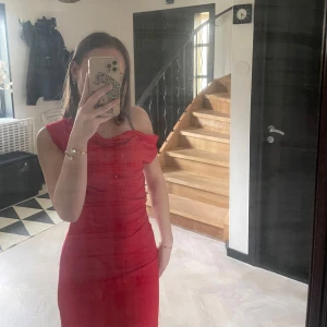 Röd klänning från BikBok - Snygg röd klänning från BikBok i storlek XS som används 1 gång på julafton . Klänningen har en offshoulder-design och en tight passform som framhäver figuren.