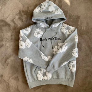 Grå Denim Tears Hoodie Med Vita Blommor - Säljer en grå Denim Tears hoodie i strl M men kan eventuellt passa S om du gillar en lite mer oversize passform. Den är i nyskick, har en justerbar huva med snören och en stor ficka framtill. Perfekt för en avslappnad stil. Vid frågor eller funderingar skicka ett pm, Mvh
