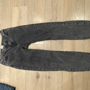 Svarta jeansbyxor - Snygga svarta jeansbyxor med en klassisk straight passform. Perfekta för en avslappnad stil. De har en traditionell femficksdesign och knappgylf.